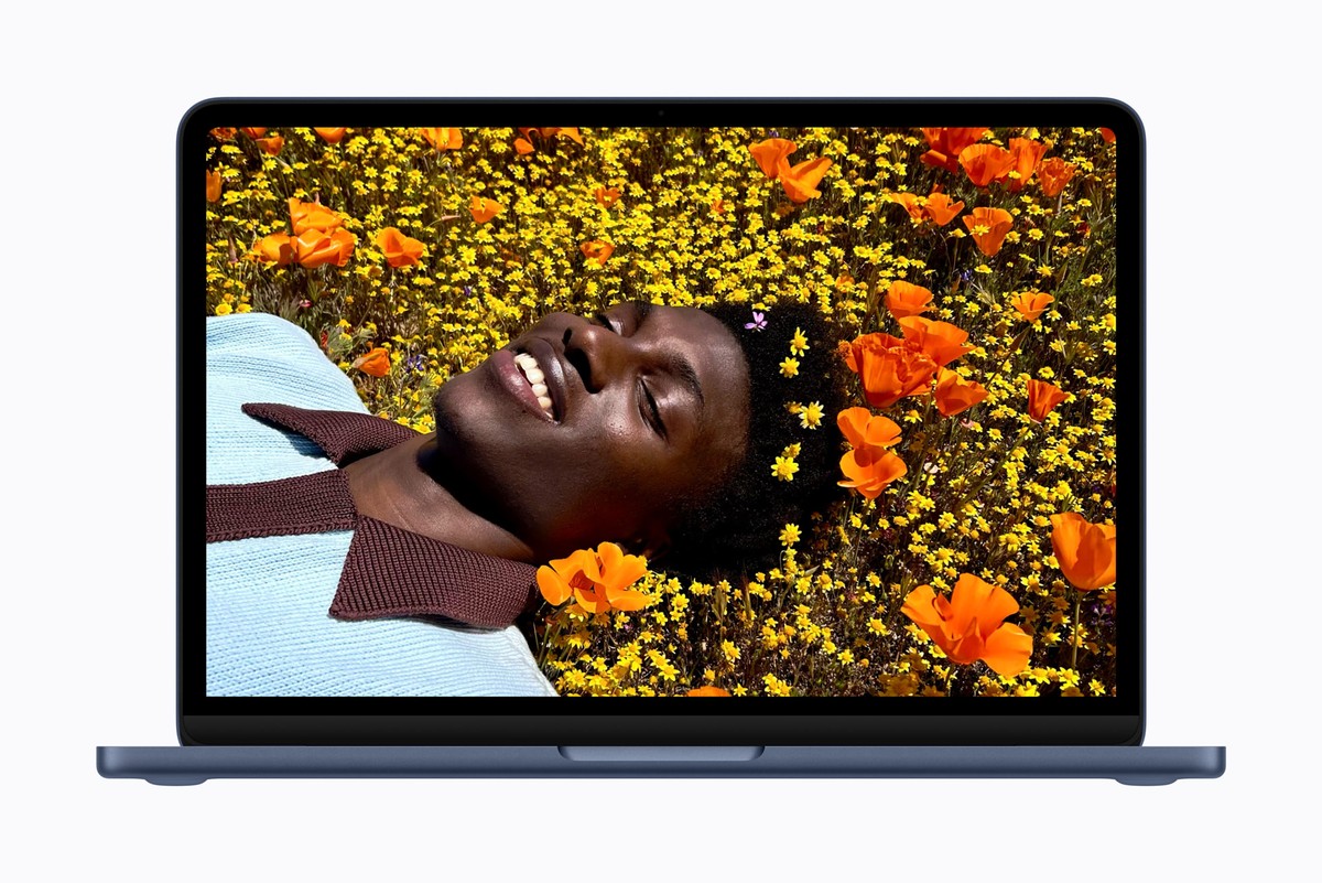 The 13-inch MacBook Neo open on a desk, its Liquid Retina display showing a colorful abstract wallpaper