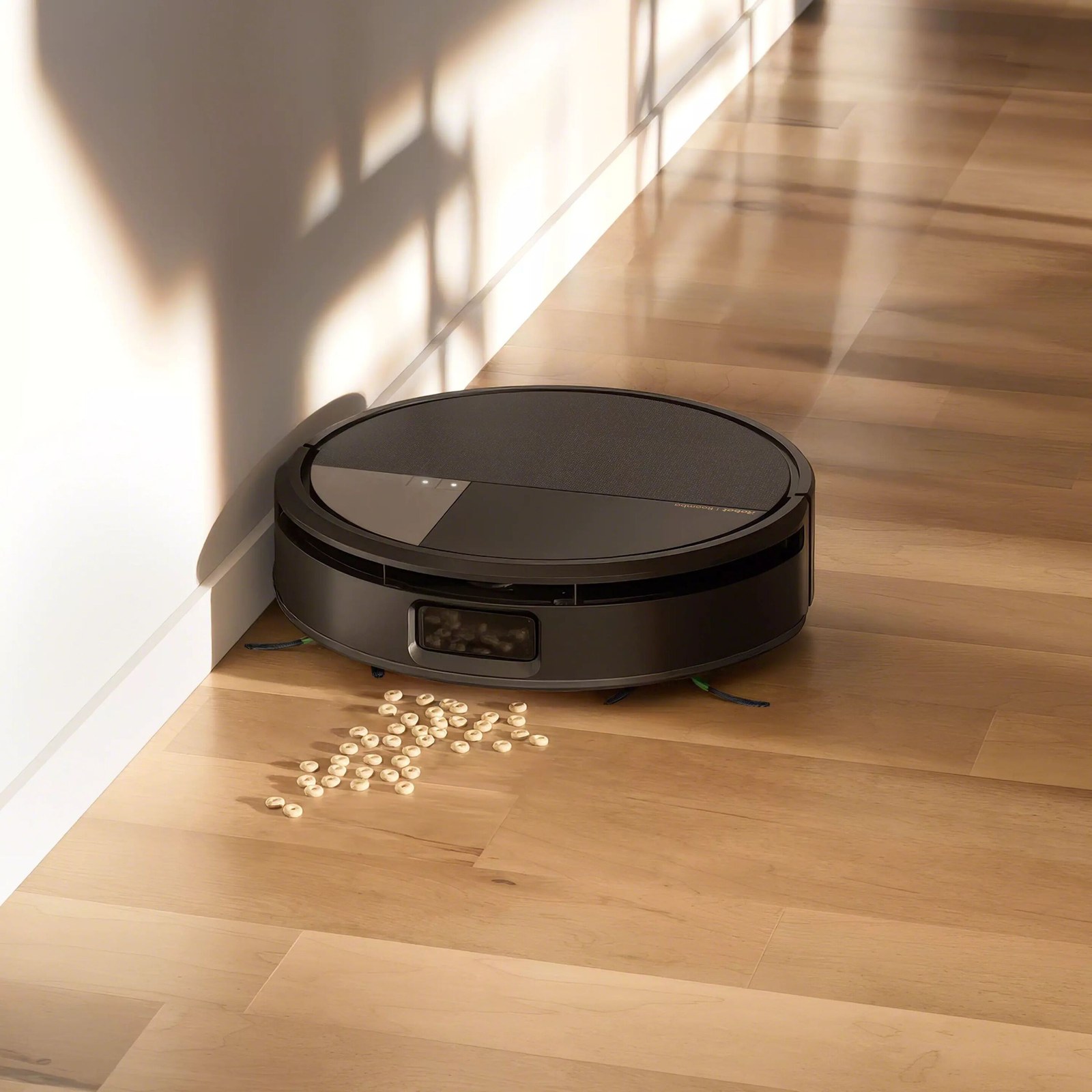 The iRobot Roomba Max 705 Combo cleaning cereal from a wood floor along a wall