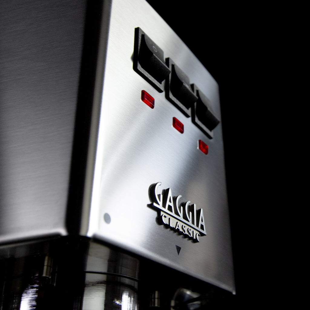 Close-up of the Gaggia Classic's brushed stainless switch panel, with its three rocker switches and indicator lights