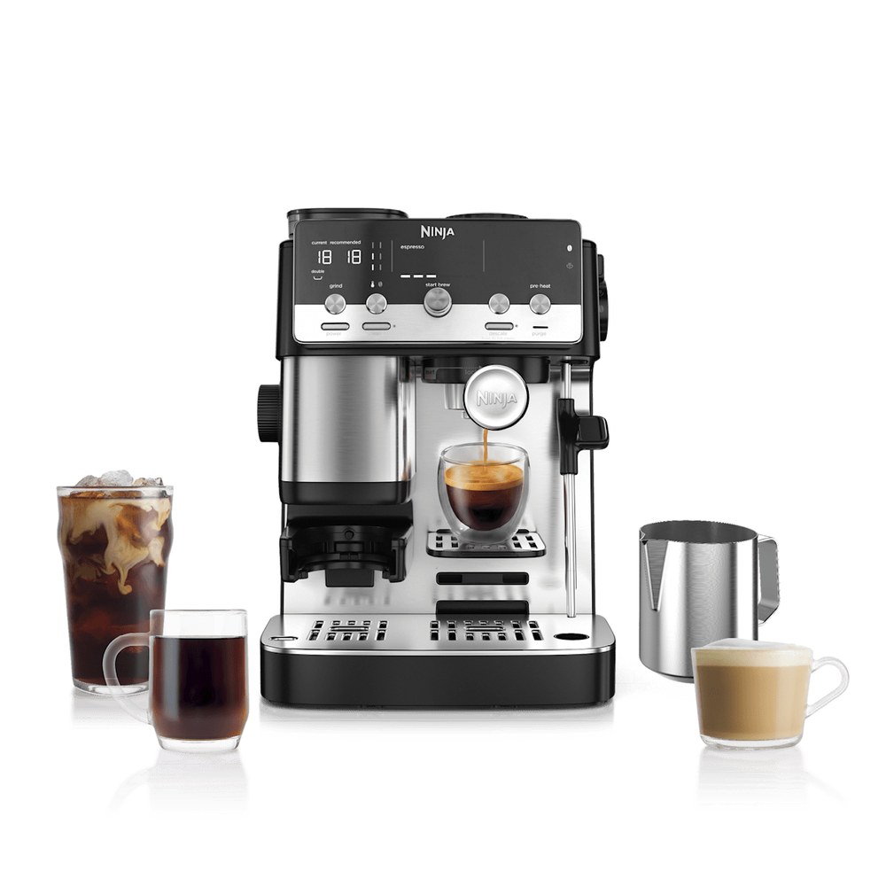 Ninja Luxe Café Mini espresso machine in stainless and black, pulling a shot beside a milk pitcher and finished café drinks