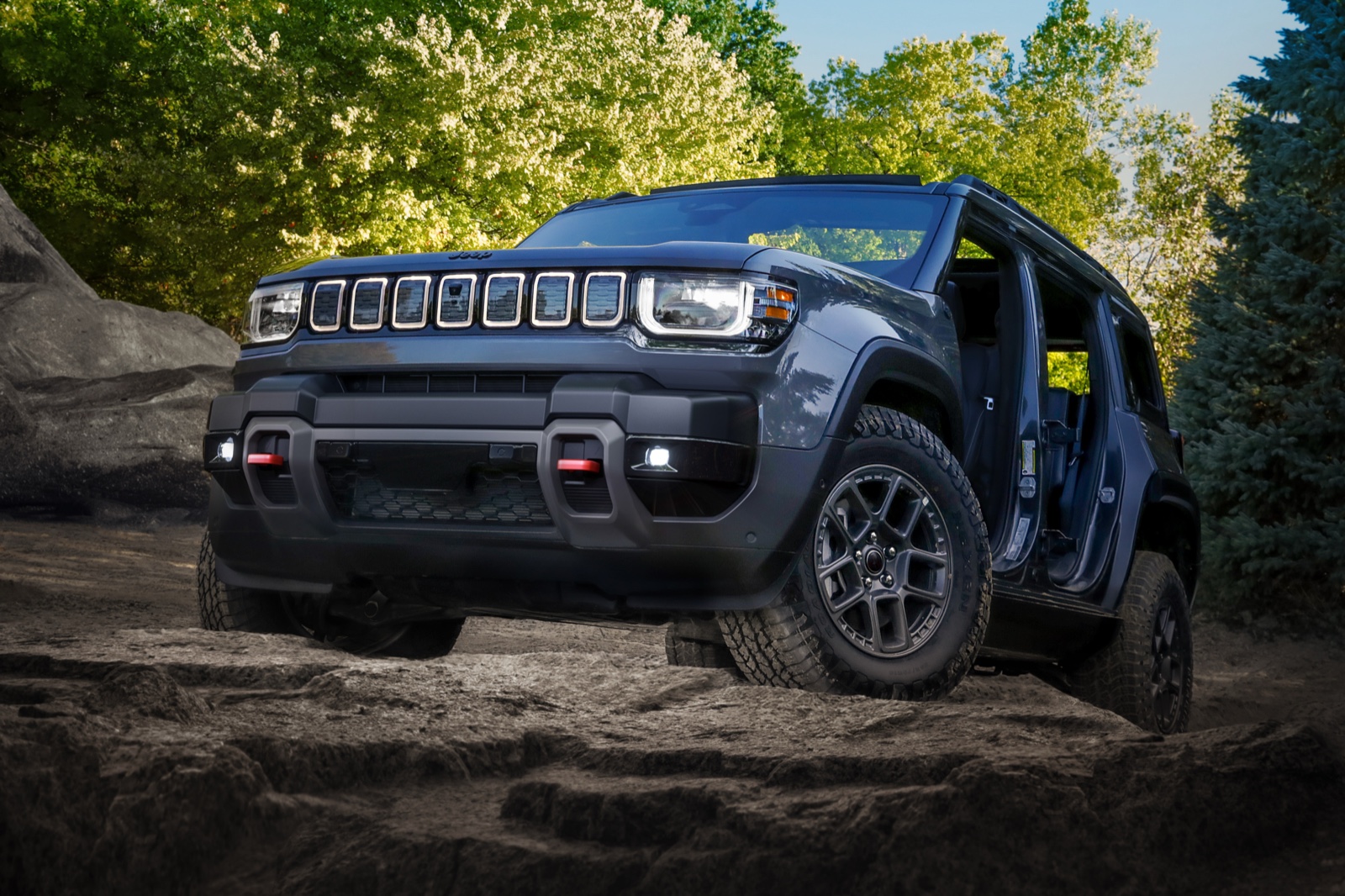 Grey 2026 Jeep Recon EV with doors removed climbing rocks