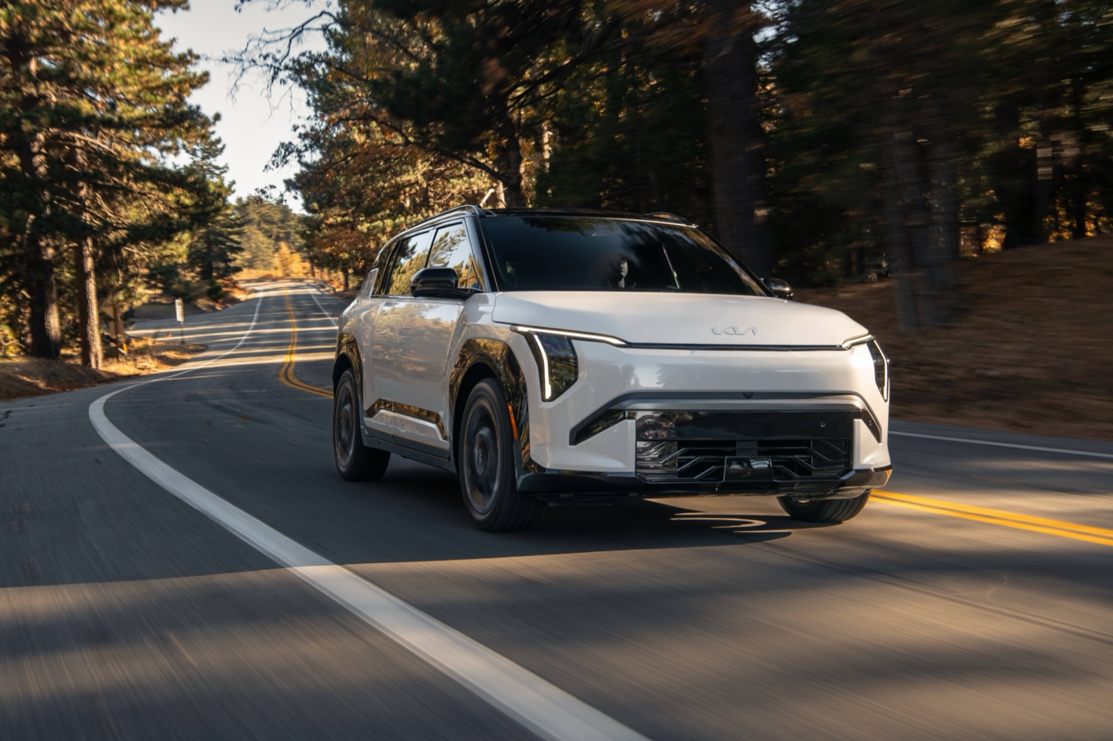 White 2027 Kia EV3 compact electric SUV driving, front three-quarter view